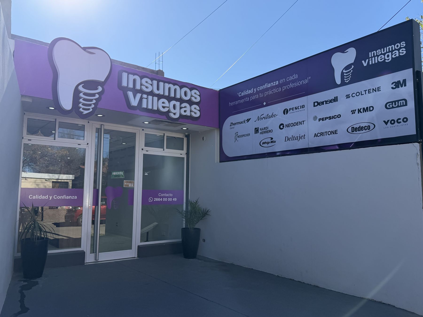 Frente del local de Villegas Insumos con el cartel violeta y el panel de marcas